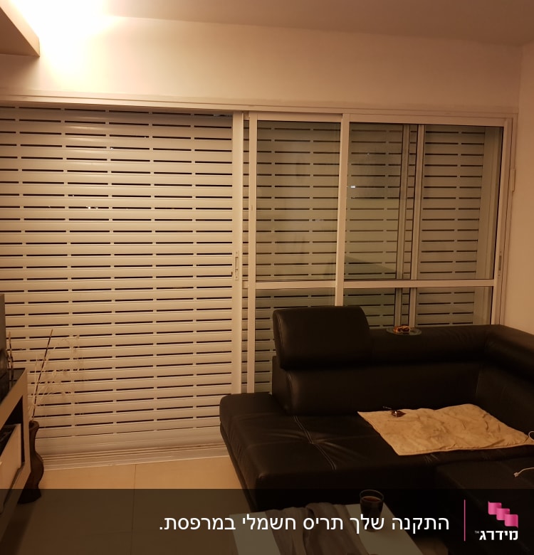 חלון אלומיניום עם תריסים סגורים בסלון